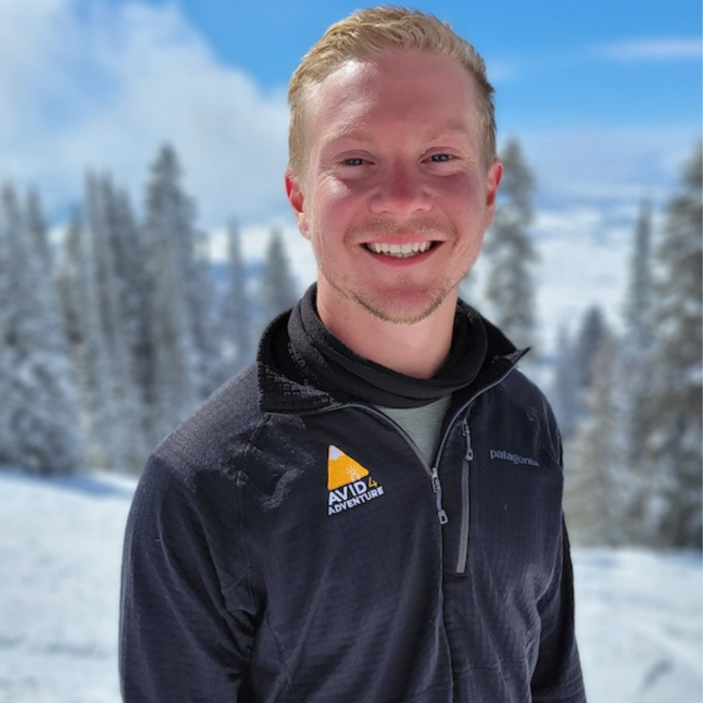 Camp staff member smiling in a snowy forest