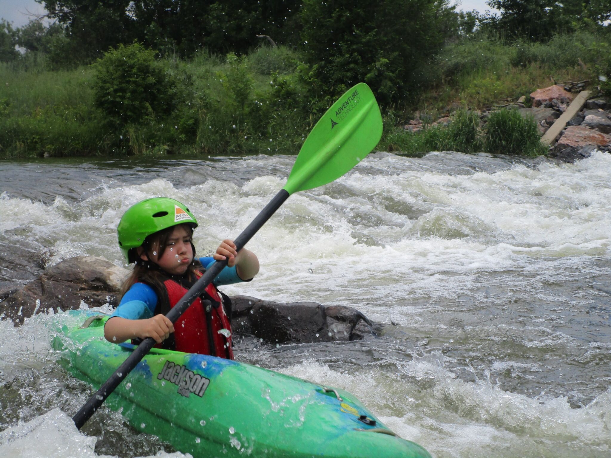 Girl kayaking in white water river